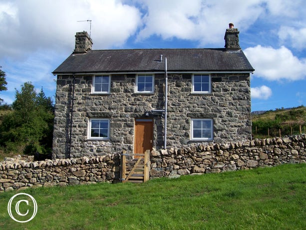 This lovely stone former farmhouse stands in a secluded location on the slopes below Cadair Idris